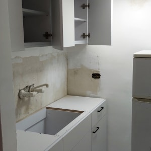 ארונות מטבח לבנים פתוחים עם ידיות שחורות