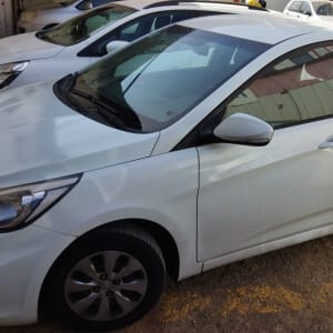 מכונית לבנה חונה עם פגושים ופנסים קדמיים