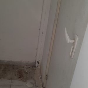 רצפה מלוכלכת עם שאריות בנייה ליד דלת