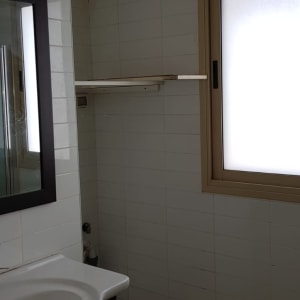 כיור ומראה בחדר אמבטיה עם אריחים לבנים