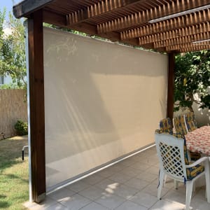 סוכך עץ עם מסך בד לבן בחצר