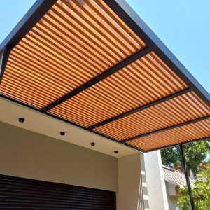 פרגולה מעץ עם קורות עץ ומסגרת מתכת