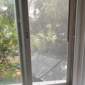 חלון עם מסגרת מתכת ומסך רשת