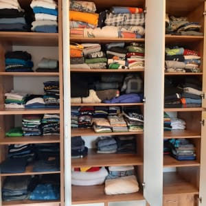 ארון בגדים מסודר עם חולצות מקופלות על מדפים