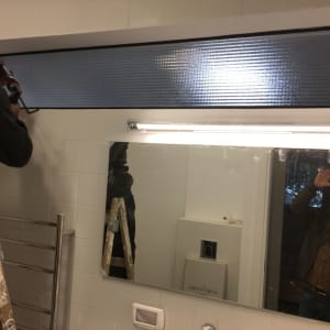 אדם עובד על מסגרת אלומיניום עם כלי עבודה