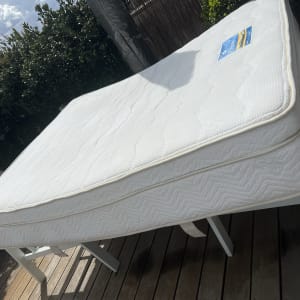 מזרן לבן מונח על שולחן עץ בחוץ