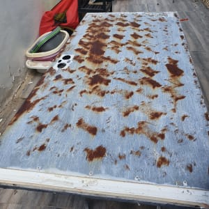 דלת מתכת חלודה מונחת על שולחן עבודה