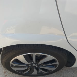 פגוש רכב לבן עם שריטה מעל הגלגל האחורי