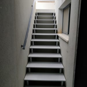 מדרגות מתכת עם מעקה בצד ימין