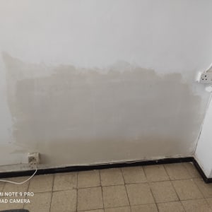 קיר צבוע חלקית עם סימני צבע טריים