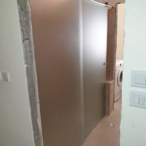 דלתות זכוכית חלבית במקלחת עם מסגרת מתכת