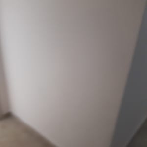 קיר צבוע בלבן עם צללים קלים