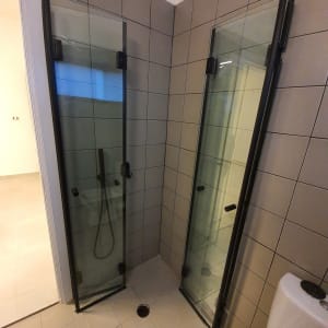 מקלחון עם דלתות זכוכית ומקלחת יד