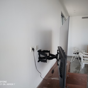 טלוויזיה מותקנת על זרוע מתכווננת על קיר