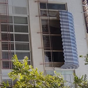 סוכך פסים כחול לבן על חלון בניין