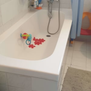 אמבטיה עם צעצועים ומוצרי רחצה על הקיר