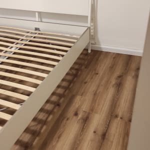 רצפת עץ נקייה ליד מיטה לבנה