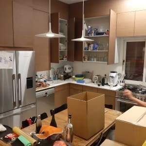 מטבח עם ארונות פתוחים, קופסאות קרטון על השולחן