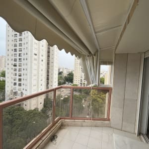 מרפסת עם סוכך בד מתקפל בצבע בהיר