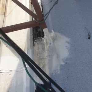 איטום גג עם חומר לבן סביב עמוד מתכת