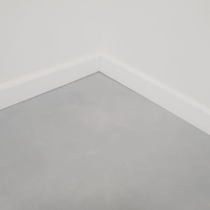 פינת קיר עם ריצוף אפור ופנלים לבנים