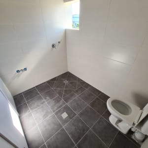 חדר אמבטיה עם אריחים חדשים ואסלה מותקנת