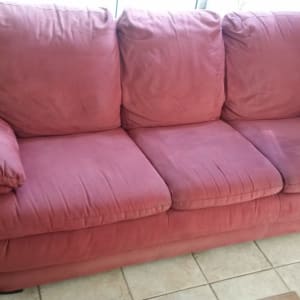 ספה אדומה עם כריות על רצפת אריחים