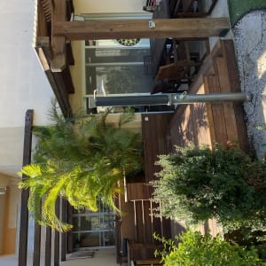 דק עץ עם צמחייה ירוקה ומקלחת חיצונית