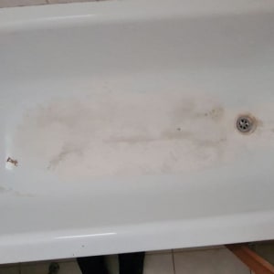אמבטיה לבנה עם כתמים וחור ניקוז