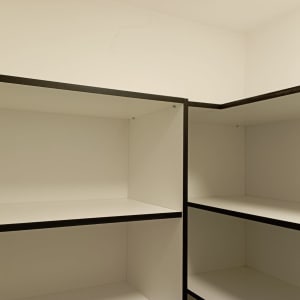 מדפים לבנים עם מסגרת כהה בפינת חדר