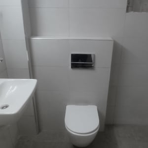 שירותים עם קיר אריחים לבנים בתהליך שיפוץ