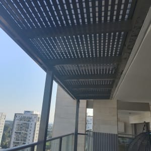 פרגולה מאלומיניום על מרפסת עם גג מחורר