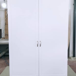 ארון לבן עם דלתות ומגירות בסדנת נגרות