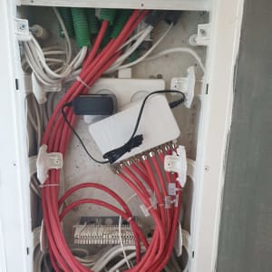 ארון תקשורת עם כבלים אדומים ולבנים מחוברים למפצל