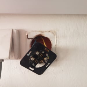 חוטי חשמל צבעוניים מחוברים לתושבת חשמל בקיר