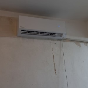 מזגן קיר לבן מותקן על קיר עם תצוגה דיגיטלית