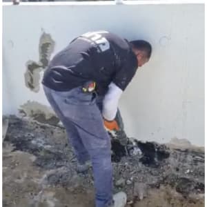 אדם עובד עם כלי עבודה על קיר לבן