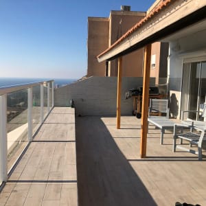 מעקה זכוכית אטום במרפסת עם נוף לים