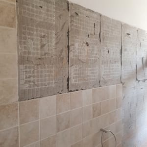 קיר עם אריחים מוסרים בתהליך שיפוץ