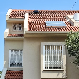 גג רעפים אדום עם קולטן שמש ומיכל מים