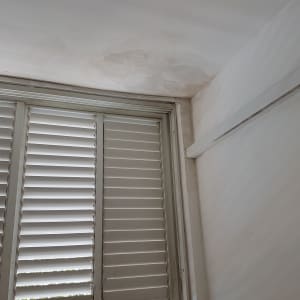 קיר עם סימני רטיבות ותקרה צבועה חלקית