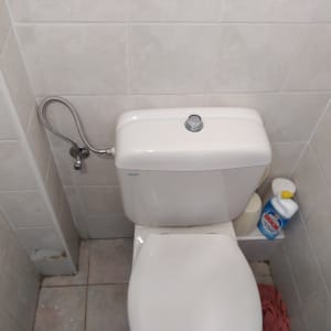 אסלה עם מיכל הדחה וצינור מים גמיש