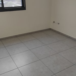 רצפה נקייה עם אריחים אפורים בחדר ריק