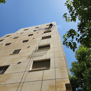 אדם תלוי על חבלים בגובה בניין