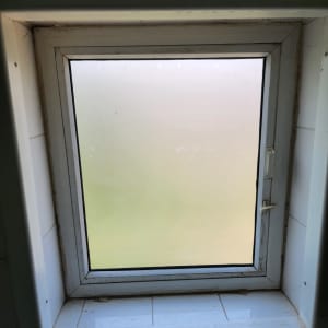 חלון זכוכית מט עם מסגרת לבנה