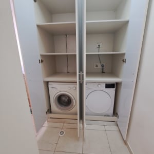 ארון פתוח עם מדפים ומכונות כביסה