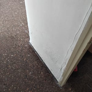 קיר עם סימני תיקון טיח ליד הרצפה