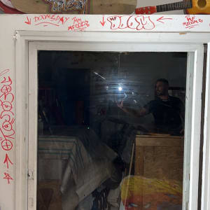 חלון זכוכית עם השתקפות של אדם וחפצים בחדר.