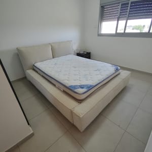 מזרן על מיטה מרופדת בחדר שינה