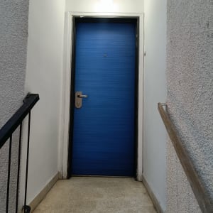 דלת כחולה עם ידית כסופה ומנורה מעל